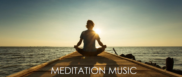 Young-man-sitting-and-meditating-on-a-pontoon-by-a-lake-at-the-sunrise